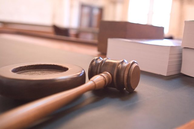 A judge's gavel on a courtroom bench