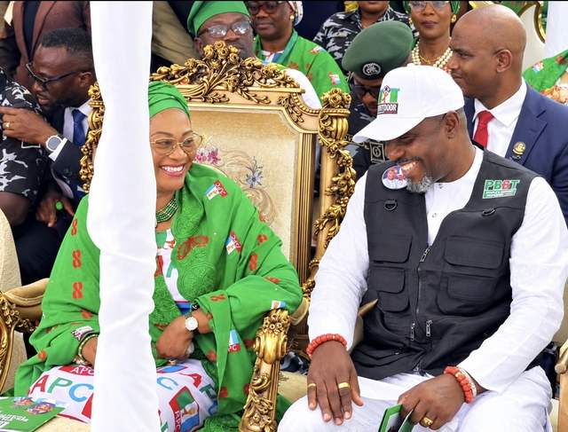 Remi Tinubu in green APC attire smiles at Tompolo, seated beside her in a white cap and black vest